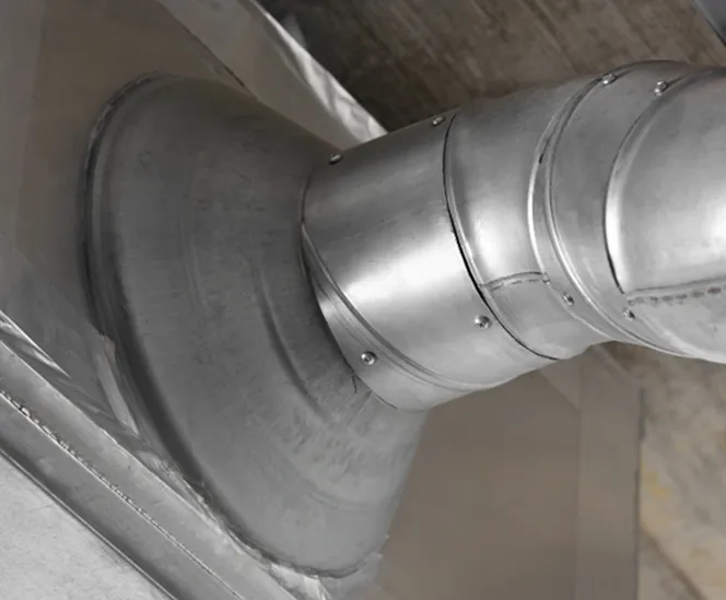 Technicien BATEA réalisant un nettoyage de conduit de cheminée avec système rotatif et aspiration HEPA